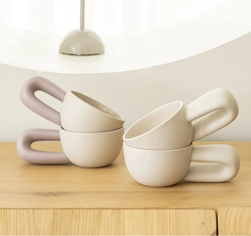 Set of white and pink ceramic bowls on a wooden surface with a neutral background